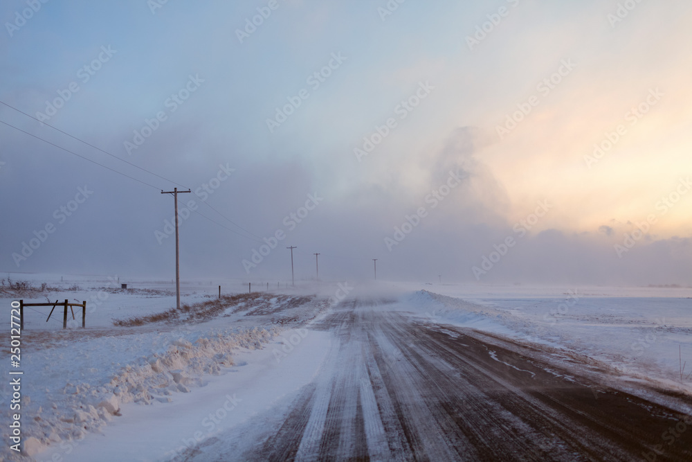 Snow blown rural roads make winter driving hazardous in farm country of New York State, USA.