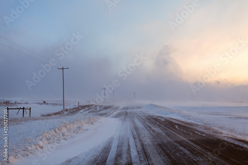 Snow blown rural roads make winter driving hazardous in farm country of New York State, USA.