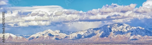 Winter Panoramic view of Snow capped Wasatch Front Rocky Mountains, Great Salt Lake Valley and Cloudscape from the Bacchus Highway. Utah, USA.