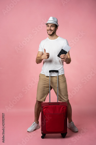 Man traveler with suitcase, passport and ticket on color background.