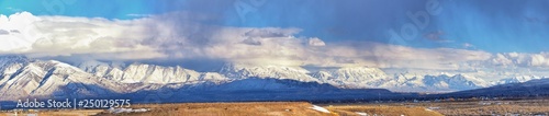 Winter Panoramic view of Snow capped Wasatch Front Rocky Mountains  Great Salt Lake Valley and Cloudscape from the Bacchus Highway. Utah  USA.