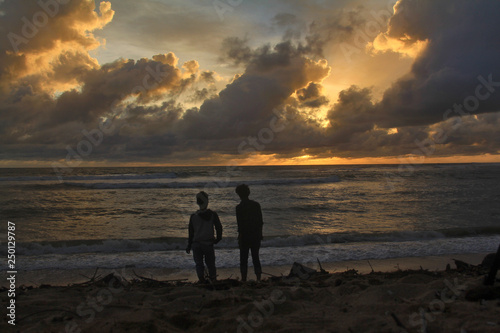 People Watch Cloudy Sunset at the Beach