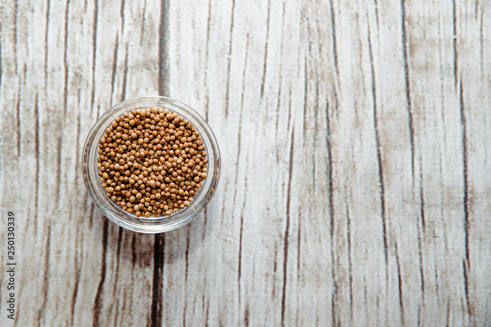 Coriander seeds on a wooden table in a bowl. Coriander placed on the table. The concept of using seasonings for dishes. Eating spiced dishes. Coriander seeds on a wooden table in a bowl. Coriander placed on the table. The concept of using seasonings for dishes. Eating spiced dishes.