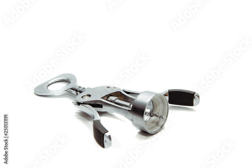 A nice silver wine corkscrew on a white, isolated background. The corkscrew lies on the table. The concept of opening wine bottles, removing corks from the bottle.