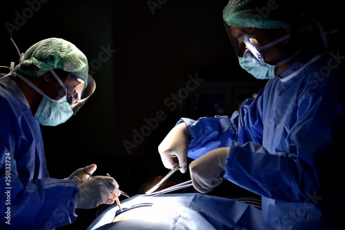 Team surgeon at work in operating room. Surgical light in the operating room. Preparation for the beginning of surgical operation with a cut. 