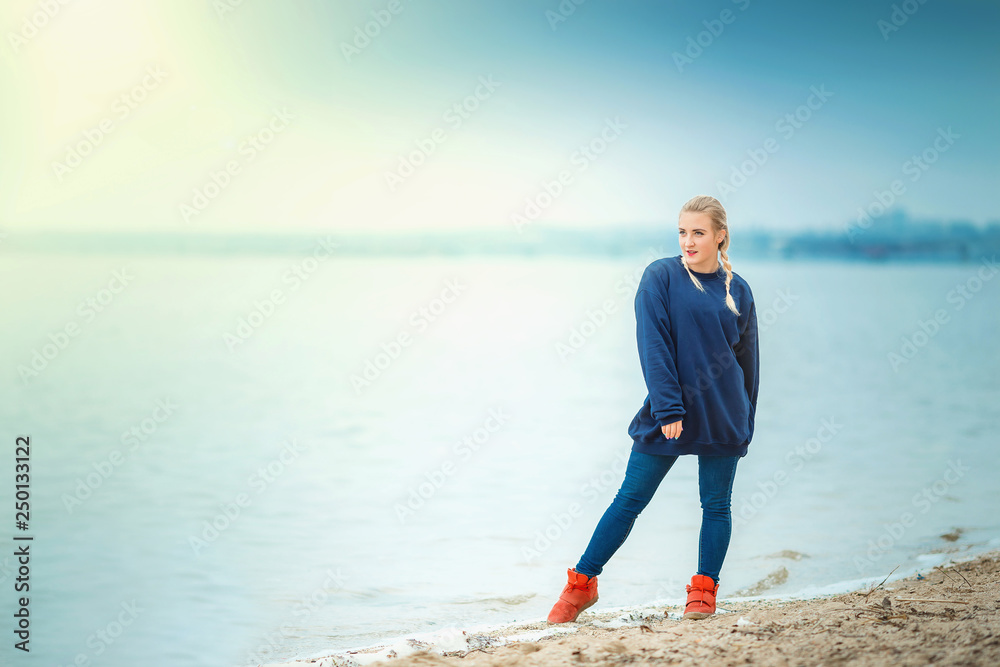 young woman posing on the river Bank in spring or autumn