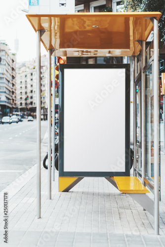Photography Billboard placeholder template inside of city bus stop near the highway; vertica