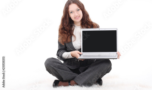 young business woman showing a laptop sitting on the floor