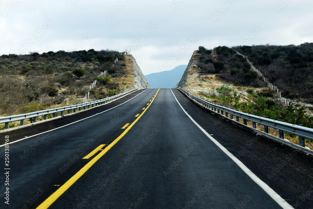 Empty black road in the mountains. Photo taken just outside Oaxaca, Mexico Empty black road in the mountains. Photo taken just outside Oaxaca, Mexico
