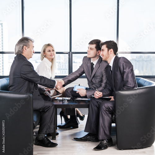 handshake business partners before beginning business negotiations on the background of applauding photo