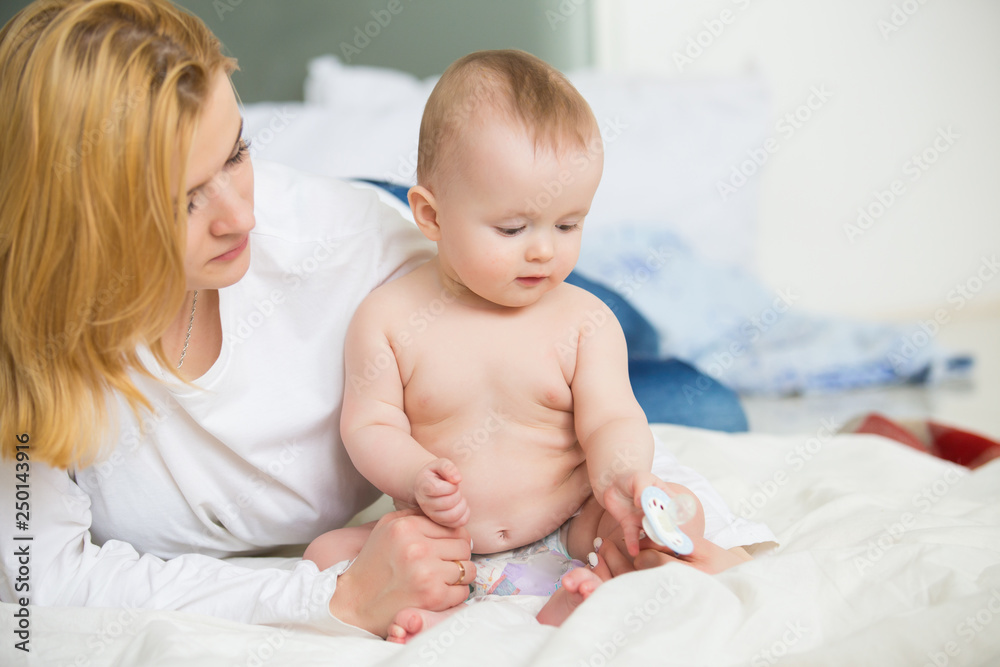 Young infant boy kissing with mother at home Young infant boy kissing with mother at home