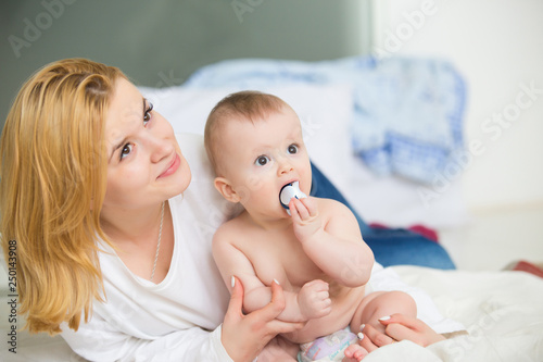 Young infant boy kissing with mother at home