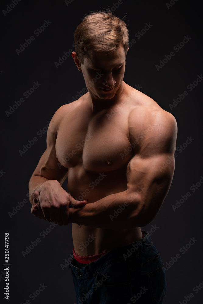 Fototapeta premium Athlete, bodybuilder, on black. Gym advertising, fitness, sports club. Healthy lifestyle concept