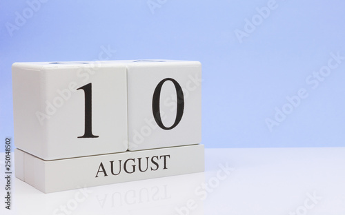 August 10st. Day 10 of month, daily calendar on white table with reflection, with light blue background. Summer time, empty space for text