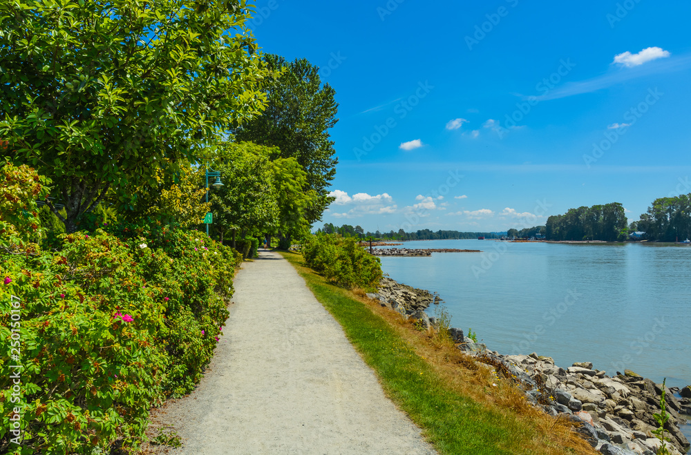 Walk way on river side close to the water. Fraser river side path in Vancouver, British Columbia. Peace of mind view