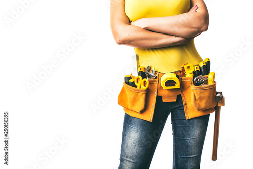 Handywoman with folded arms and tool belt isolated on white background.