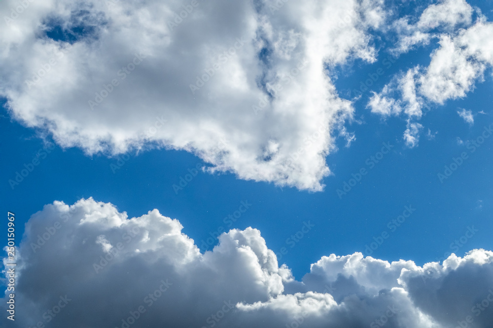 Obraz premium fluffy white clouds in a sun shower