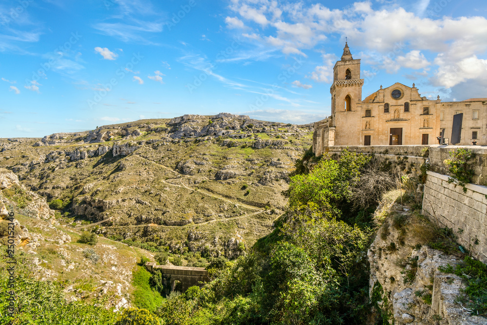 The Church of San Pietro Caveoso sits atop a steep cliff and overlooks the canyon, ravine and prehistoric sassi cave dwellings in Matera, Italy.