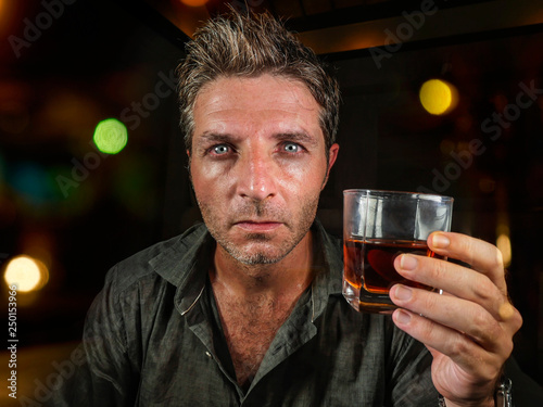 messy and wasted man drunk at night club or bar drinking whiskey glass looking hammered celebrating party or suffering alcoholism problem and alcohol addiction