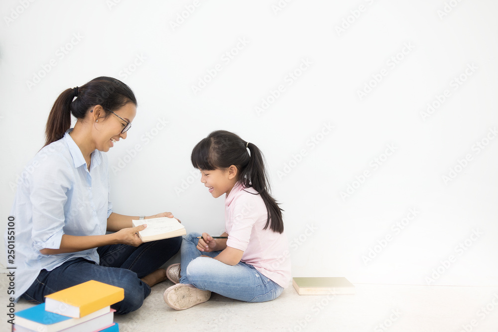 young mother and daughter sitting on floor white wall background. Adult education, Education Knowledge Concept young mother and daughter sitting on floor white wall background. Adult education, Education Knowledge Concept