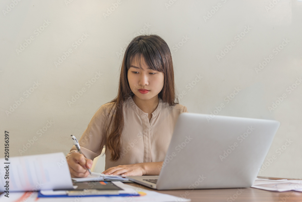 Asian employee writing notes in the office room Asian employee writing notes in the office room