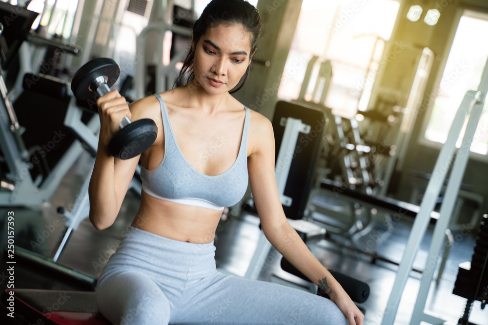 Youn sexy sport women exercise with dumbbell work out in the gym Youn sexy sport women exercise with dumbbell work out in the gym
