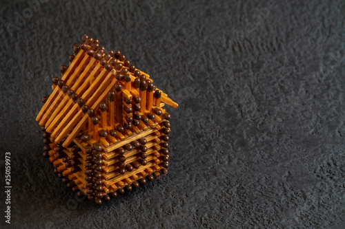 Little house model of matches on a dark background photo