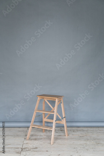 The working space of the photo studio with a grey paper background and chair.