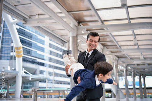 Family concept. Dad and son are playing fun toys. A businessman is carrying his son inside the city.