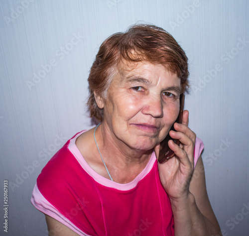 an elderly woman with a phone near her ear photo