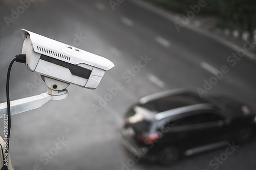 cctv camera watching over traffic with blur black car in the background, Bangkok, Thailand.