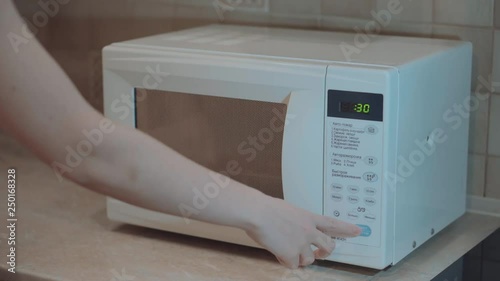 Heated food in the microwave. Female hand puts pies in the microwave in the lunch box. Cooking in the microwave. 4k video.