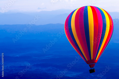 Colorful hot air balloon on blue mountain background