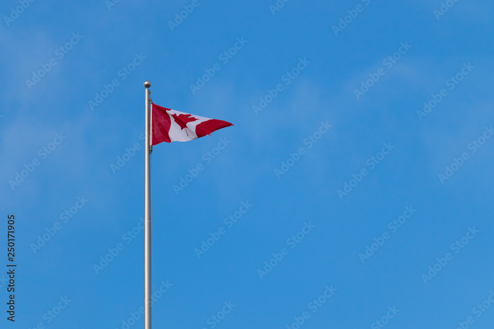 Canadian flag against bright blue sky, with copy space Canadian flag against bright blue sky, with copy space