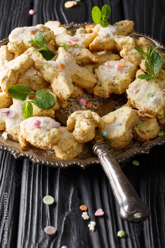 Mexican Christmas hojarascas cookies with pecans closeup on a plate. vertical photo