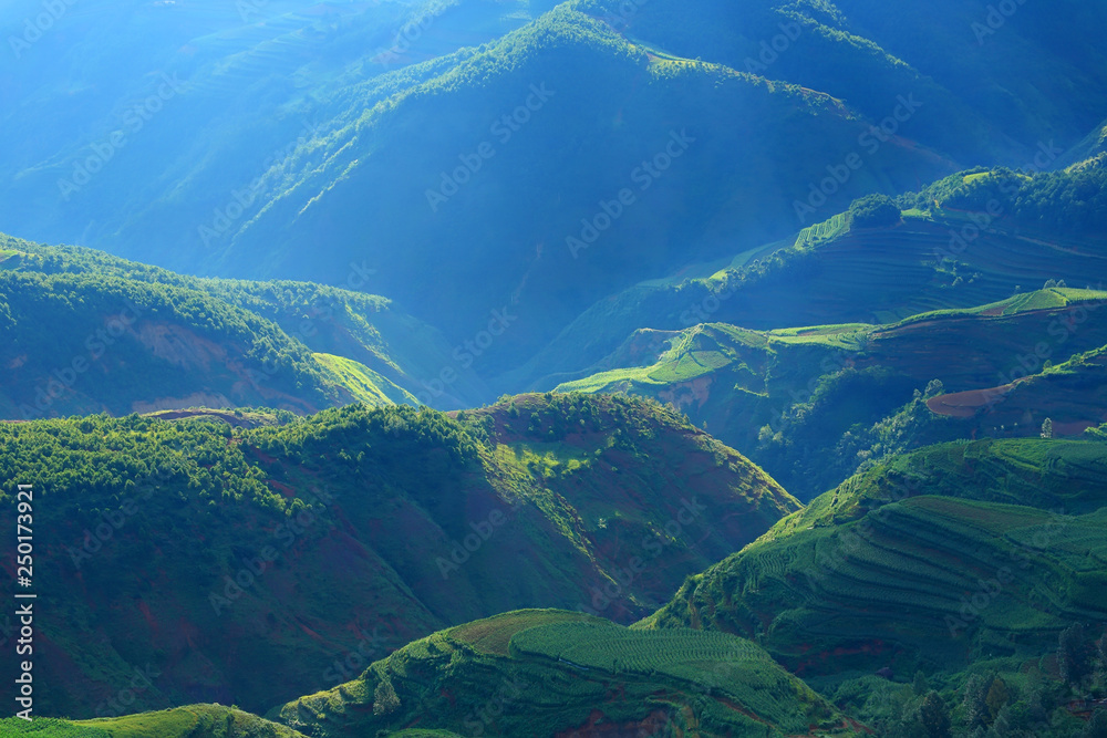 Beautiful light beam in morning with red soil and village on mountain valleys at Hongtudi,Dongchuan,Yunnan,Kunming of China Beautiful light beam in morning with red soil and village on mountain valleys at Hongtudi,Dongchuan,Yunnan,Kunming of China