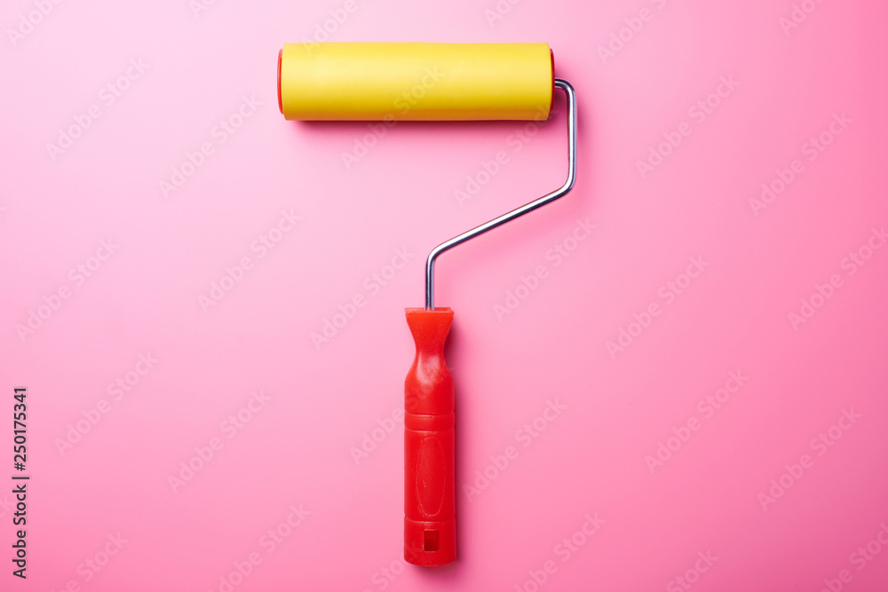 Home repair concept. Yellow roller for wallpaper and pink wall with copy space. Home repair concept. Yellow roller for wallpaper and pink wall with copy space.