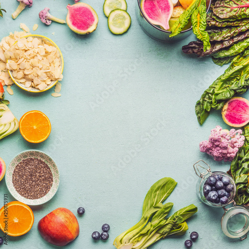 Healthy smoothie ingredients on light table, top view. Various fruits , vegetables and berries with almond, chia seeds and pine nuts for tasty vegan   nutrition. Smoothie preparation with blender