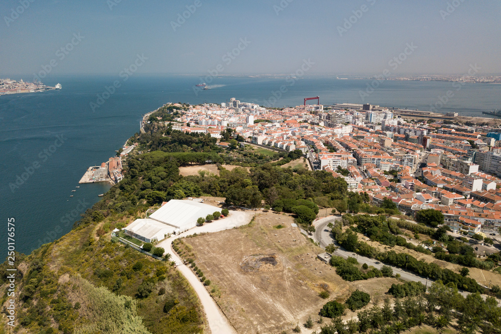 The coastline of Lisbon. The mouth of the river Tagus. Urban landscape with houses, technical facilities and a port. The view from the top.