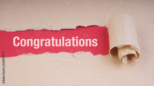 CONGRATULATIONS text on brown envelope and torn paper. Concept Image