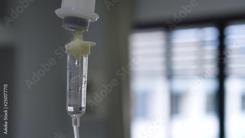 Dripping of set iv fluid intravenous drop saline solution in hospital room.