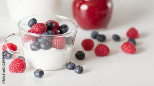 Yogurt with blueberry and raspberry berries in a glass Cup on a white background. Breakfast. Healthy diet.