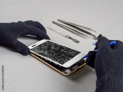 Technician or engineer opening broken smartphone for repair or replace new part on desk