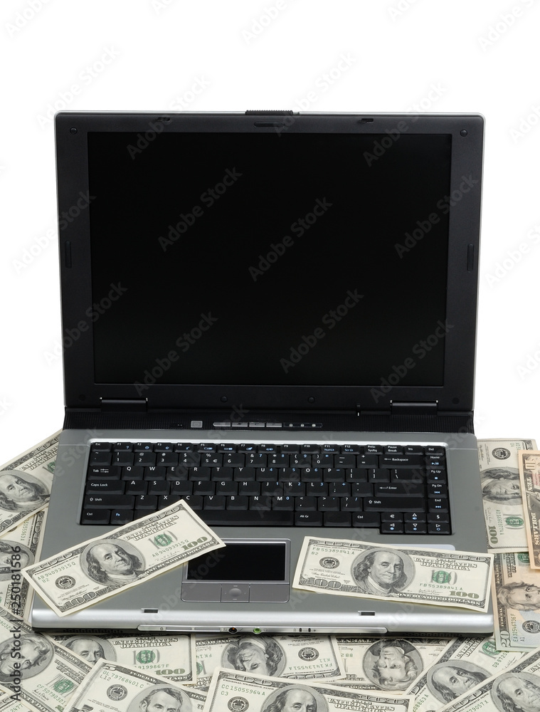 Hundred-dollar bills lying on laptop Hundred-dollar bills lying on laptop