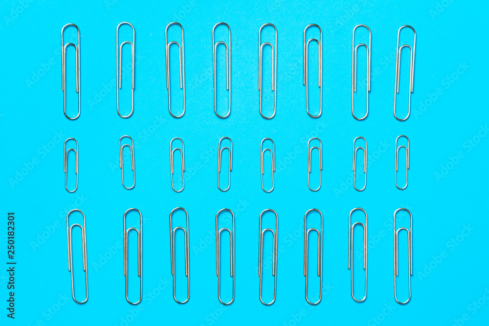 paper clips on pastel blue background, copy space. Top view, flat lay paper clips on pastel blue background, copy space. Top view, flat lay