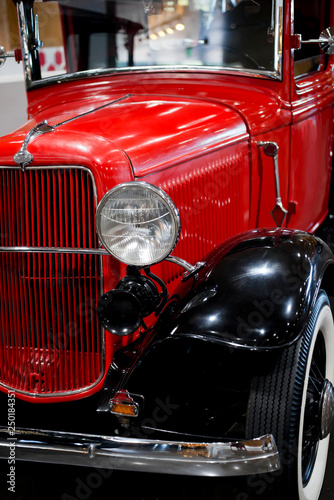 Front view of an elegant red retro car on exhibition of old vintage car