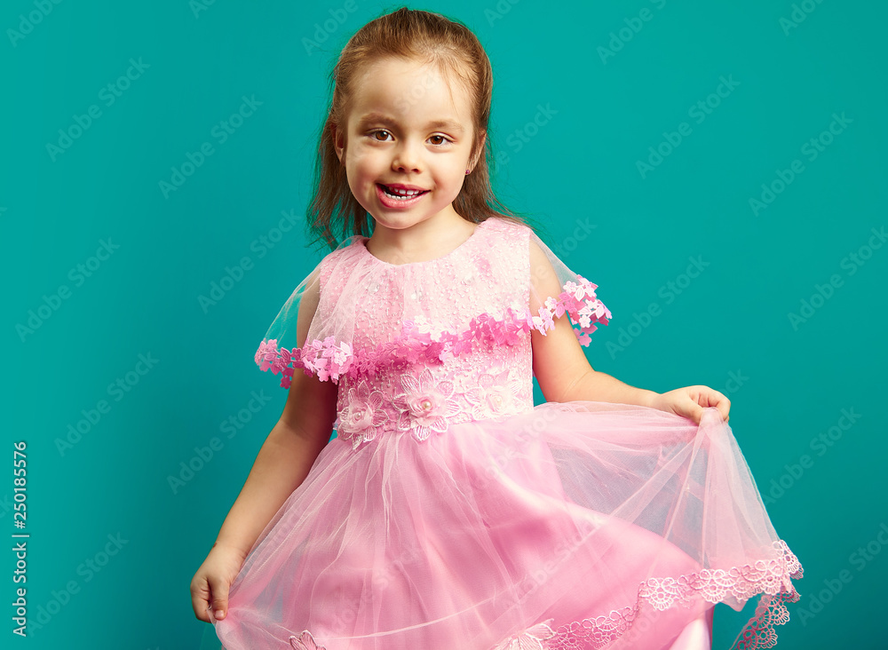 Beautiful baby girl wears pink dress on blue isolated Beautiful baby girl wears pink dress on blue isolated