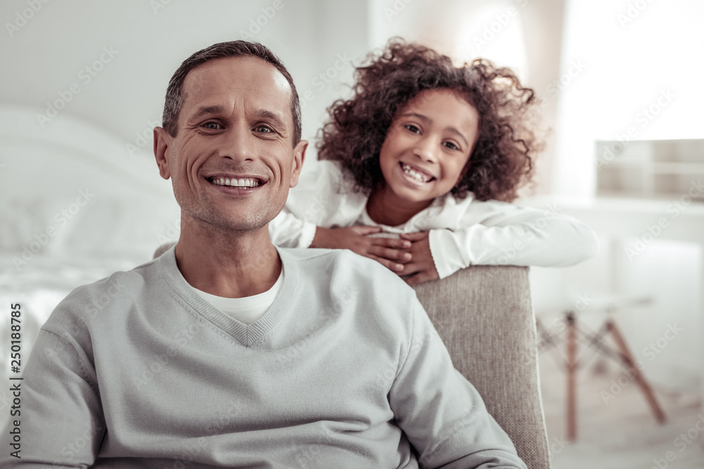 Obraz premium Joyful cheerful father and daughter looking at you very attentively