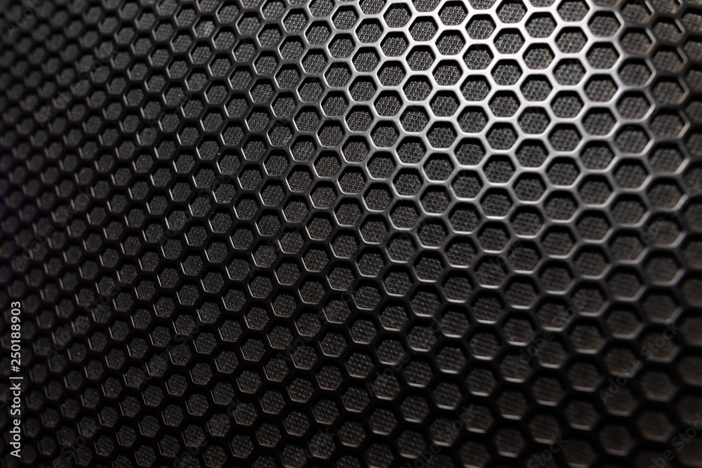 Musical powerful speaker with a protective grill close-up Musical powerful speaker with a protective grill close-up