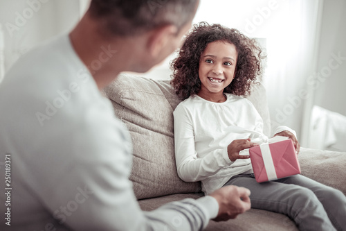 Excited careful father giving a nice present to a daughter